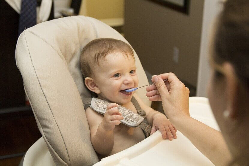 Bebê sendo alimentado com alimento sólido